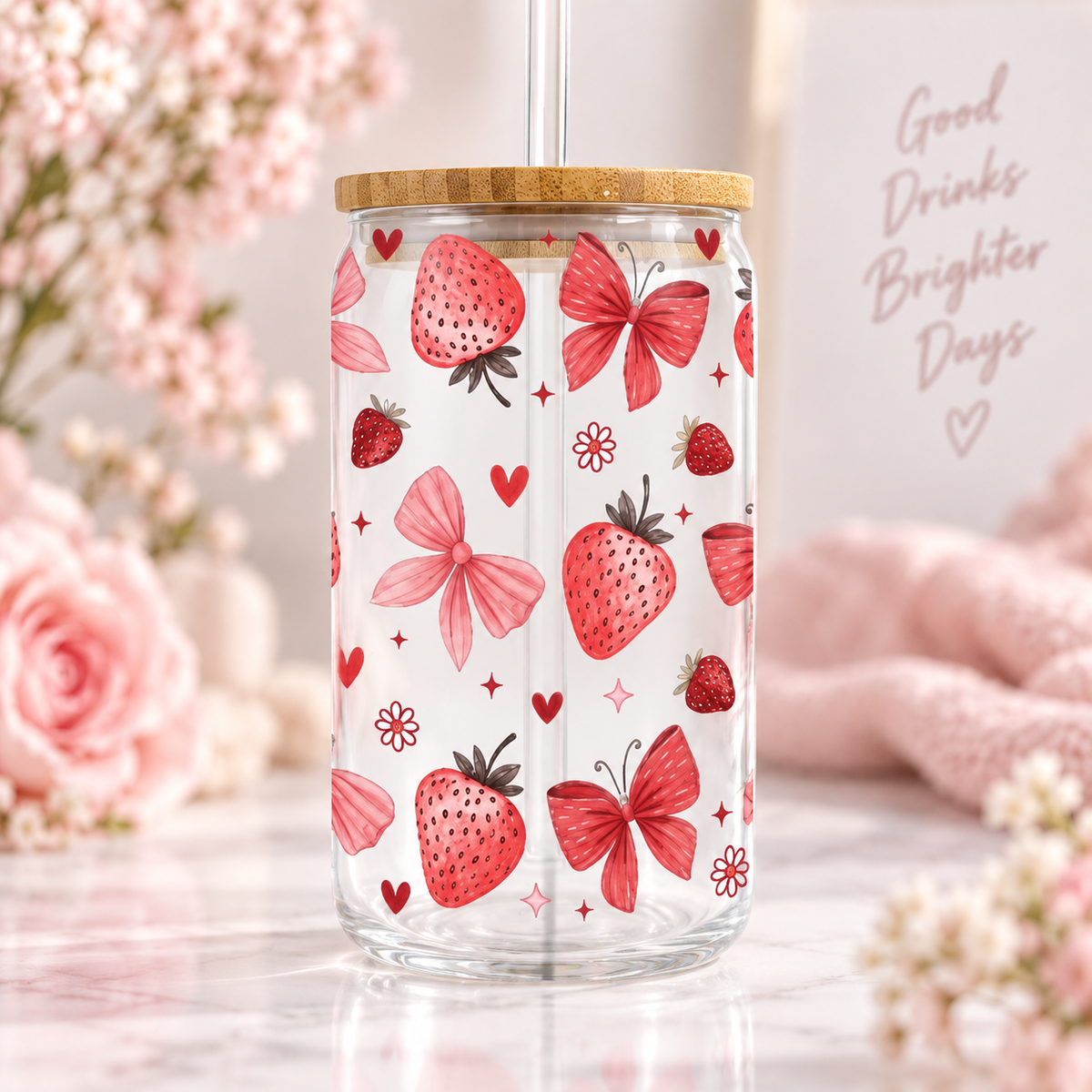 Strawberry Bow glass can with bamboo lid and straw in a soft styled setting